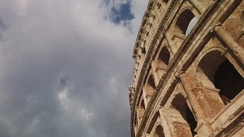 Imposing arches of the Colosseum with a cloudy sky are painted orange at sunset Video stock 137133547