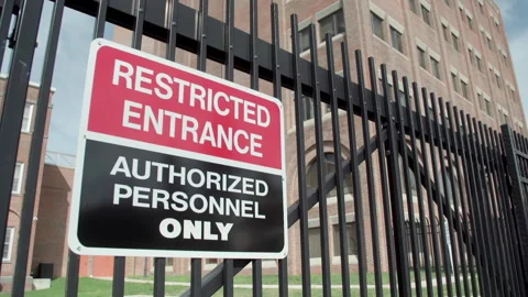 Imposing building behind fence with restricted entrance sign Stock Footage 141210420