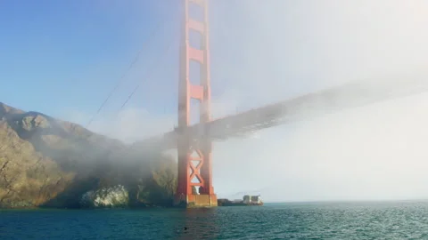 Imposing Golden Gate Bridge is covered in early morning fog, Pacific Ocean view 스톡 동영상 242829328