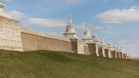 The imposing wall of an old monastery, consisting of white stupas and red b.. Stock Photos