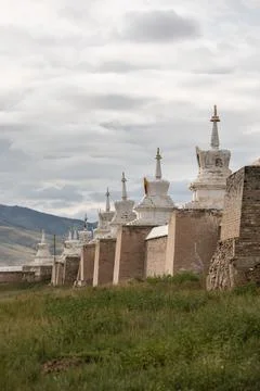 The imposing wall of an old monastery, consisting of white stupas and red b.. Stock Photos