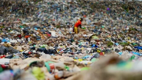 Impoverished man stuff a bag full of supplies scavenged from a garbage Video stock 136839410