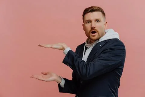 Impressed man presenting something and being in shock Stock Photos