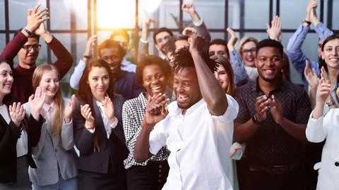 Impressed young coworkers clapping and looking at camera Stock Photos