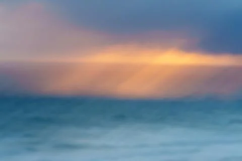 Impressionist coastal with diagonal motion effect through clouds, golden gl.. Stock Photos