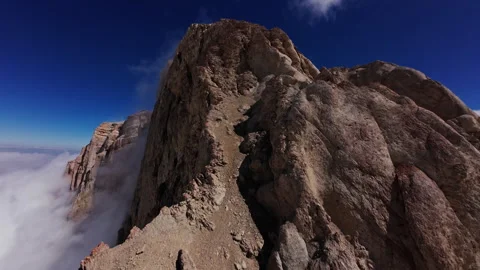 Impressive aerial perspectives capture a rugged mountain peak rising above a Stock Footage 304527095