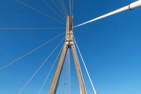 Impressive architectural cables of modern cable-stayed bridge against blue sky Stock Photos
