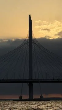 Impressive cable-stayed bridge silhouette over rippling water at dusk, set Stock Photos