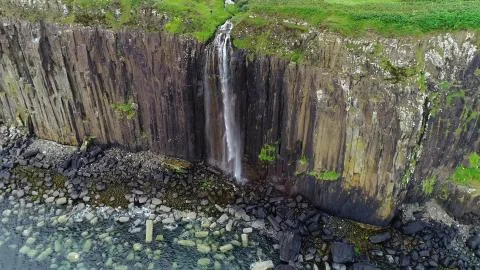 Impressive coastline on the cliffs with a bewitching waterfall Stock Photos