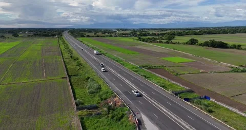 An impressive highway captured in a shot with lush rice fields flanking Stock Footage 282966184