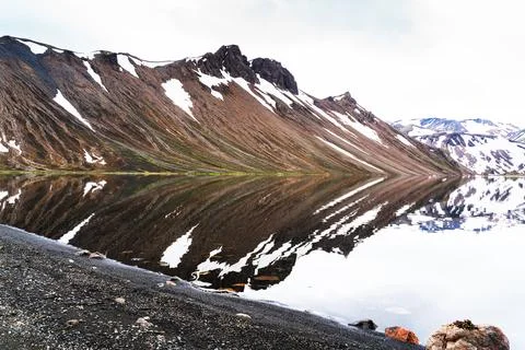 Impressive view of reflection of beautiful mountain covered with snow. Stock Photos