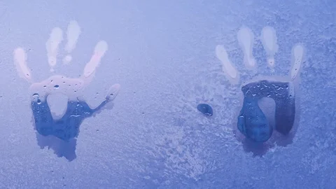 The imprint of two hands on the icy window, the drops are flowing Stock Footage 329233710