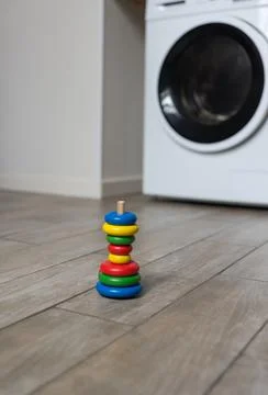 An improperly assembled multi-colored childrens pyramid stands on the floor i Stock-Fotos