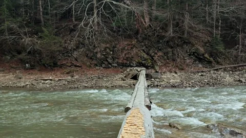 Improvised Log Bridge Crossing over Rushing Mountain River 4K Stock Footage 335098945