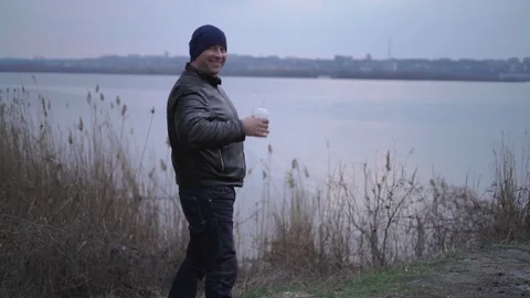 The Improvising Man Picks up a Plastic Cup and Laughs on the River,sunset Sky Stock Footage 73904689