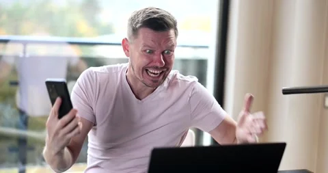 Impulsive angry man screaming into phone and laptop Stock Footage 267000835