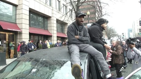 Inaugural Protesters Sit on Trashed Car Stock Footage 71801569