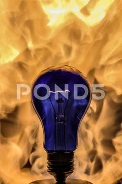 The incandescence bulb (lamp) close up view with flame background Stock Photos