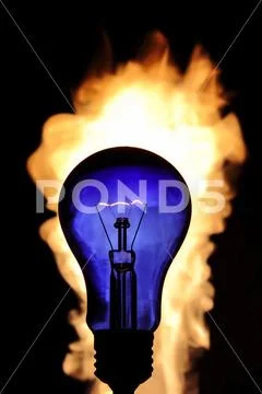 The incandescence bulb (lamp) close up view with flame background Stock Photos