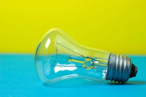 Incandescent lamp on a colored background. Stock Photos