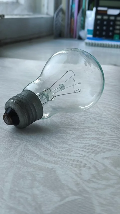 The incandescent lamp is on the table. the concept of increasing electricity Stock Footage 316286617