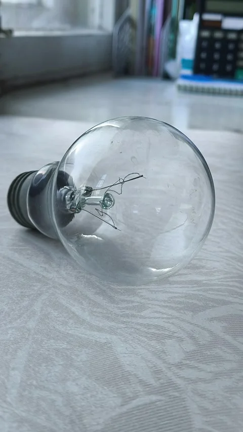 The incandescent lamp is on the table. the concept of increasing electricity Stock Footage 316286646