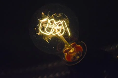 Incandescent light bulb on a dark background Stock Photos