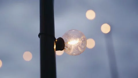 An incandescent light bulb illuminates the space around with warm light Stock Footage 296486554