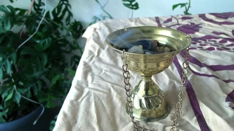 Incense burning in metal container on table Video stock 235317199