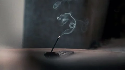 Incense burning on a table and smoking Stock Footage 345077322