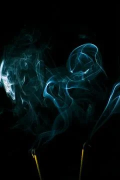 Incense smoke creates a variety of pattern shapes on a black background 스톡 사진