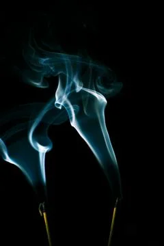 Incense smoke creates a variety of pattern shapes on a black background 스톡 사진