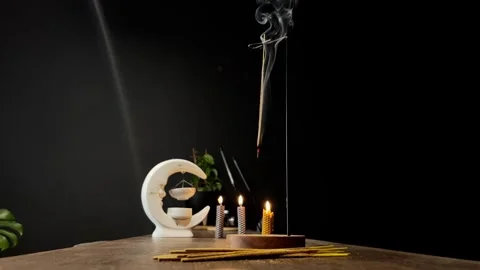 An incense stick burning and generating aromatic smoke surrounded by small Stock Footage 293019012