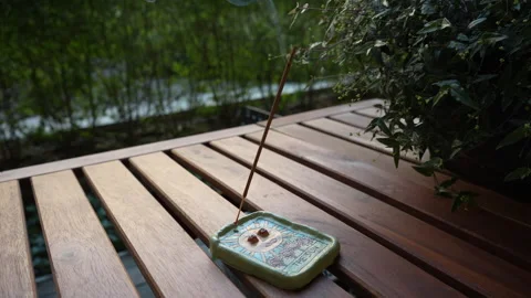 The incense stick smokes in an esoteric clay holder with the sun painted on it Video stock 249965587