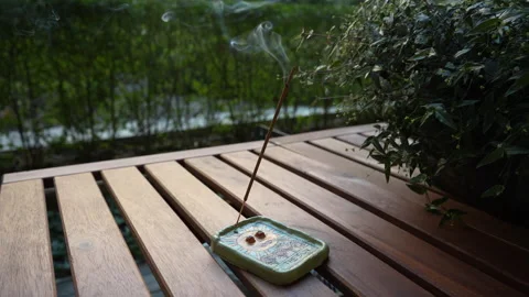The incense stick smokes in an esoteric clay holder with the sun painted on it Stock Footage 249965613