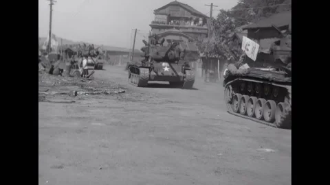INCHON - 1950 - US medium tank rolling through a street. LCM ships coming Stock Footage 308103676