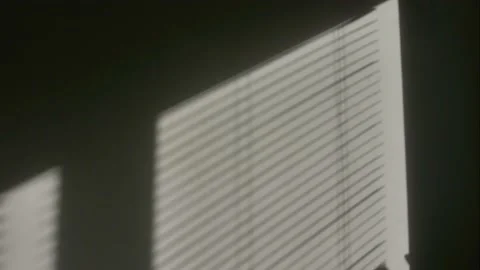Incident light falls through the window blinds. light moves along the wall. Stock Footage 233179811