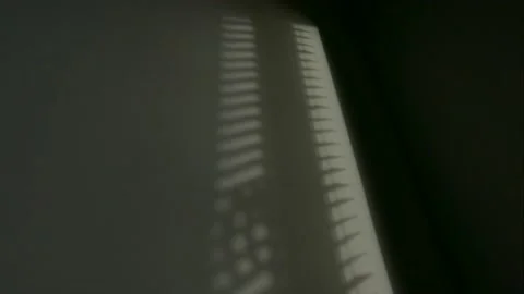 The incident light falls through the window blinds. light moves along the wall. Video stock 233450871