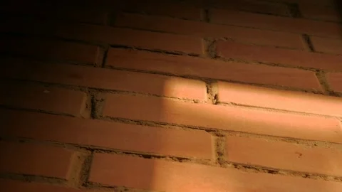 Incident light from a window moves along a brick wall. Video stock 144588803