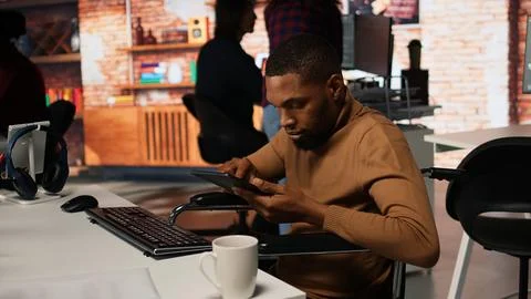 Inclusive software development agency worker with paraplegia uses tablet 写真素材