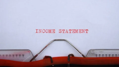 Income statement - phrase printed on an old typewriter in red letters, close up. Stock Footage 128399757