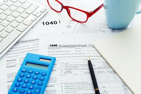 Income tax return form with computer keyboard calculator and notebook Stock Photos