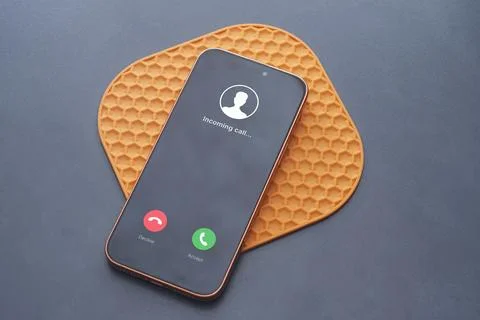 Incoming call interface displayed on modern smartphone on a table. Concept .. Stock Photos