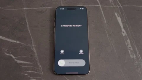 Incoming call from an unknown number on smartphone placed on table Stock Footage 334041212