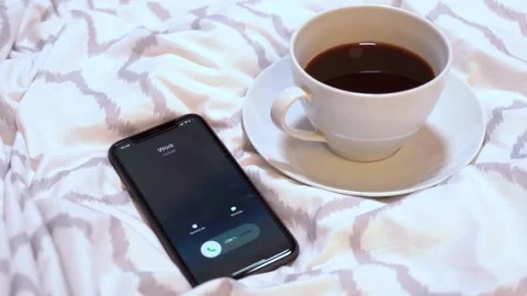 Incoming call from work and cup of coffee on the bed Stock Footage 150283342