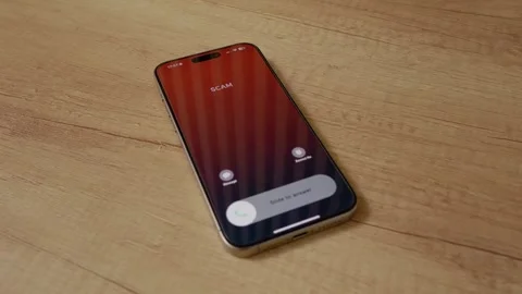 Incoming scam call on smartphone shows potential danger on wooden table Stock Footage 334043992