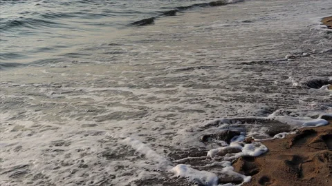 The incoming wave washes away the footprints in the sand. Stock Footage 221184155