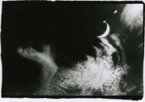 An incomplete moon and clouds in the sky. Stock Photos