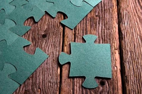 Incomplete puzzles lying on wooden rustic boards. Stock Photos