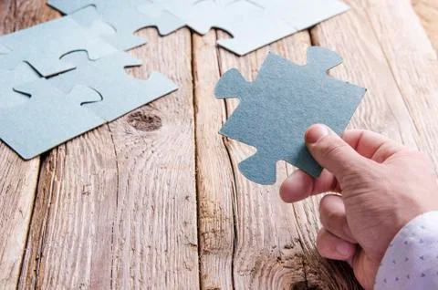 Incomplete puzzles lying on wooden rustic boards. Stock Photos